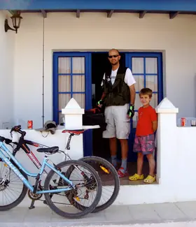 TíoCharly y uno de sus hijos en la puerta de una casa blanca con bicicletas